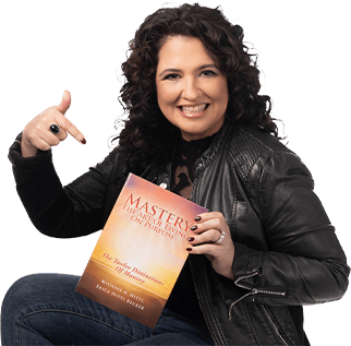 A woman holding an open book while sitting on the ground.